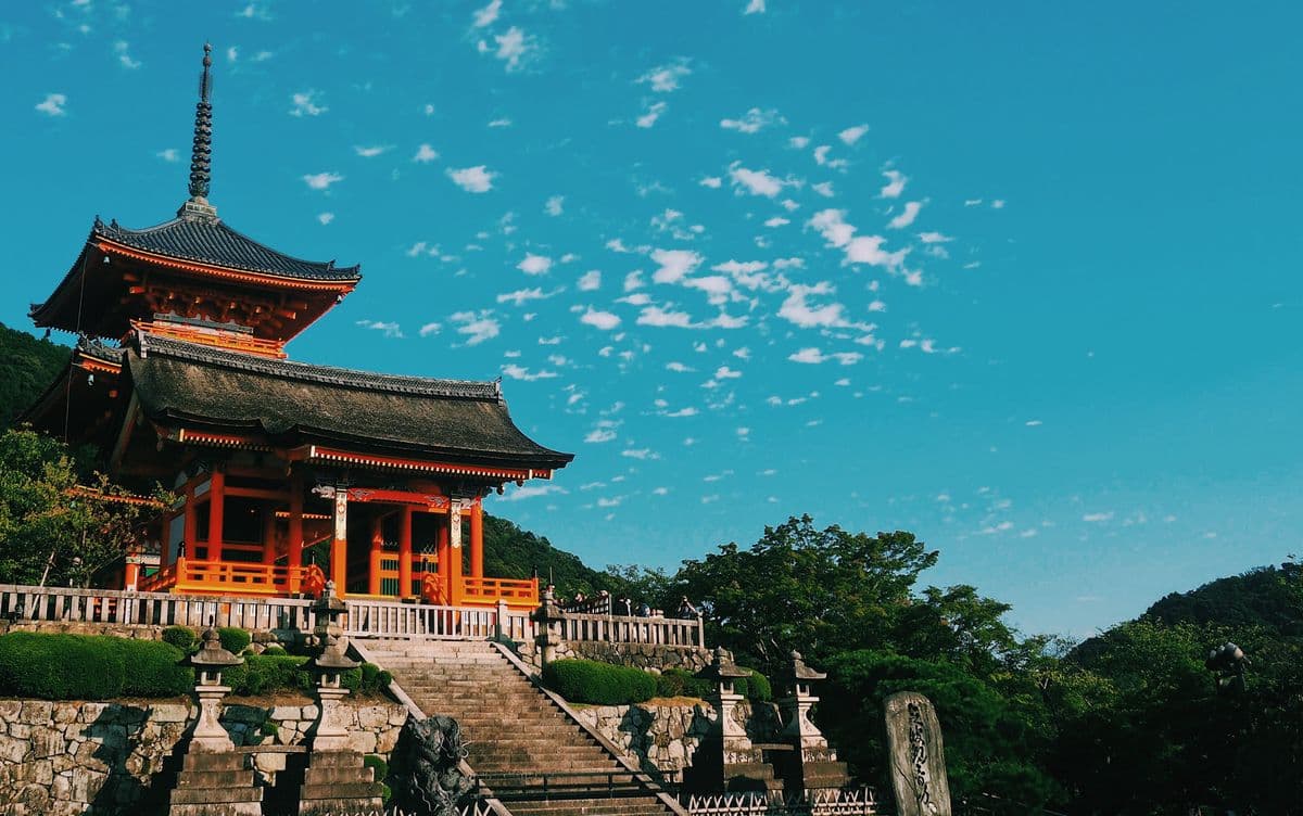Sunlit temple beneath a blue sky in Kyoto