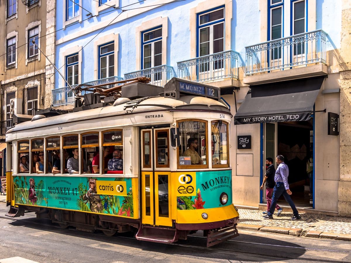 A yellow tram on a sunlit Lisbon street